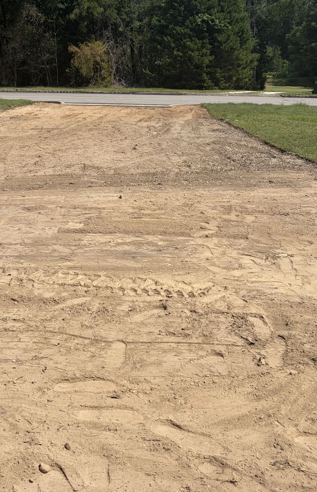 New driveway cut in and graded to bare base, before the gravel